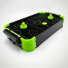 A mini air hockey table with neon green accents against a white background. Náhľad obrázku produktu