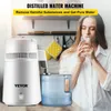 A woman drinks water next to a distilled water machine. Náhľad obrázku produktu