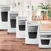 A row of Leitz shredders of varying sizes are displayed on a wooden floor in front of a blurred office background. Náhľad obrázku produktu