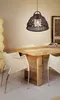 A dining room setting with a wooden table and chairs, illuminated by a pendant light. Produktbild-Vorschau