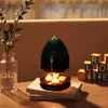 A decorative candle heater with tealights, a vase with greenery, and wooden blocks spelling 'LOVE' on a wooden table. Produktbild-Vorschau