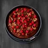 A top-down view of a chocolate cake with raspberries and chocolate shavings in a springform pan. Produktbild-Vorschau