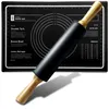 A black silicone pastry mat with circular guides and measurement markings, and a black rolling pin with wooden handles, is placed diagonally on the mat. Voir les images du produit