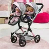 A twin doll stroller with two dolls inside, set in a child's room. Náhľad obrázku produktu