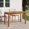 A wooden garden table with chairs on a patio next to a house. Náhled obrázku produktu