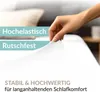 A hand is shown stretching a white fitted sheet, highlighting its elasticity. Produktbild-Vorschau