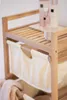 Close-up of a wooden shelf unit with fabric baskets, holding toiletries. Podgląd zdjęcia produktu