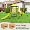 A backyard playground set with a slide and swing, shown in front of a house, with two cardboard boxes in the foreground. Produktbild-Vorschau