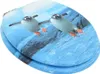 A toilet seat with a printed design of two penguins swimming in blue water. Anteprima dell’immagine prodotto