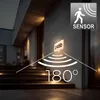 An outdoor wall light with a house number display, showing its motion and dusk sensor range and angle. Náhľad obrázku produktu
