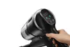 A close-up shot of a person's hand holding a black cordless vacuum cleaner, with a digital display showing '100.' Produktbild-Vorschau