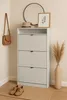 A shoe cabinet with three drawers, a hat, a framed picture, a handbag, and a vase with dried flowers. Produktbild-Vorschau