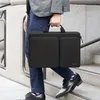 A person walks down stairs carrying a black laptop bag. Produktbild-Vorschau
