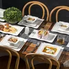 A table setting with a full dinnerware set, food, and drinks. Produktbild-Vorschau