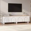 A white and wood-tone TV stand with arched cabinet doors and spherical legs, with a black TV mounted on the wall above it. Anteprima dell’immagine prodotto