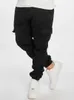 A person wearing black cargo jogging pants and white sneakers against a white background. Anteprima dell’immagine prodotto