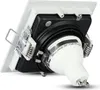 A close-up, angled view of the back of a white square LED spotlight, showing its mounting springs and electrical connection. Produktbild-Vorschau