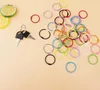 A collection of colorful metal binder rings and a set of keys on a light peach background. Produktbild-Vorschau
