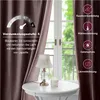 A close-up of a curtain with a window and a table with a lamp and candle in the background. Voir les images du produit