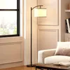 A modern living room with a floor lamp, sofa, and coffee table. Voir les images du produit
