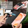 A person is holding a credit card and a phone with a wallet case, with a payment terminal in the background. Náhled obrázku produktu