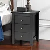 A black nightstand with three drawers is placed next to a bed. Podgląd zdjęcia produktu