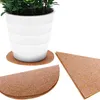 A white plant pot sits on a cork coaster, with other cork pieces in various shapes nearby. Produktbild-Vorschau