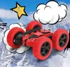 A red remote-controlled car with large red wheels is shown in a dynamic pose against a background of snowy mountains and comic-style clouds and a star. Produktbild-Vorschau