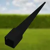 A black metal post anchor is shown against a blurred background of green grass and a blue sky. Produktbild-Vorschau