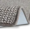 A close-up view of a carpet with a rolled edge, showing the texture and binding. Náhled obrázku produktu