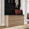 A shoe cabinet with a seat in a hallway, with clothes hanging above and a bag on the seat. Produktbild-Vorschau