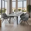 A dining room with a table and chairs set up for a meal, with a view of a city in the background. Náhled obrázku produktu