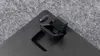 A close-up view of a black mechanical keyboard's adjustable feet. Produktbild-Vorschau