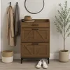 A hallway or entryway scene featuring a shoe cabinet, coats, a hat, a plant, and shoes. Podgląd zdjęcia produktu