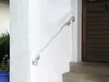 A metal handrail is mounted on a white wall next to a wooden door. Anteprima dell’immagine prodotto