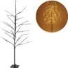 A decorative LED tree with a black trunk and branches, illuminated by small yellow lights. A circular inset shows a close-up of the illuminated tree. Podgląd zdjęcia produktu