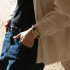 A person's hand is in their jeans pocket, wearing a watch. Produktbild-Vorschau