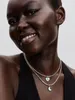 Close-up of a woman wearing two necklaces with charms. Produktbild-Vorschau