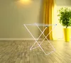 A white metal drying rack is shown in a room with wooden floors and yellow curtains. Produktbild-Vorschau