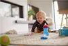 A baby is crawling on a rug with toys around. Náhľad obrázku produktu