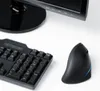 A computer monitor, keyboard, and an ergonomic mouse are arranged on a white surface. Produktbild-Vorschau