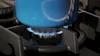 A blue pot is being heated by blue flames on a gas stove burner. Produktbild-Vorschau