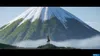 A lone rider on horseback stands on a grassy hill, gazing at a majestic snow-capped mountain shrouded in mist. Produktbild-Vorschau