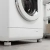 A close-up view of the bottom of a white washing machine, resting on anti-vibration feet. Anteprima dell’immagine prodotto