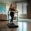 A woman is running on a treadmill in a living room. Produktbild-Vorschau