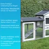 A close-up view of a grey and white outdoor pet enclosure with a ramp, set against a green hedge background. Text describing features is overlaid on a blue background on the left side of the image. Produktbild-Vorschau