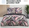 A bedding set with a tropical leaf pattern is displayed on a bed, with a potted plant in the background. Produktbild-Vorschau