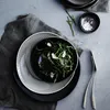 A top-down view of a table setting with plates, food, and salt. Produktbild-Vorschau