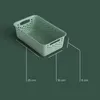 A light green storage basket with handles is shown on a dark green background, with dimensions indicated by white lines and text. Produktbild-Vorschau