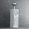 A silver paper towel holder with a roll of paper towels on a gray concrete background. Produktbild-Vorschau